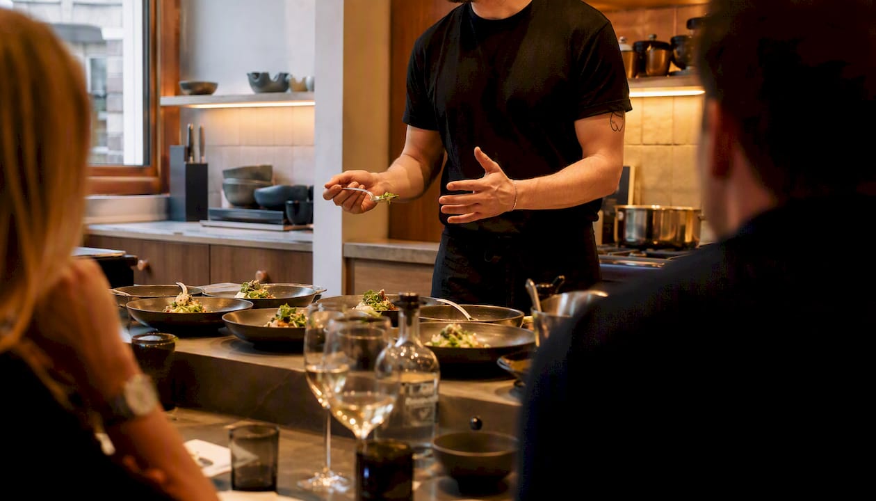 Supper club host plating food and narrating