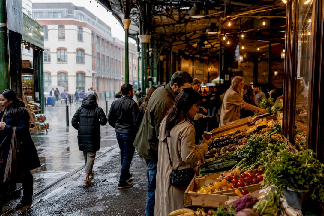 Visitors browsing Borough Market in rain