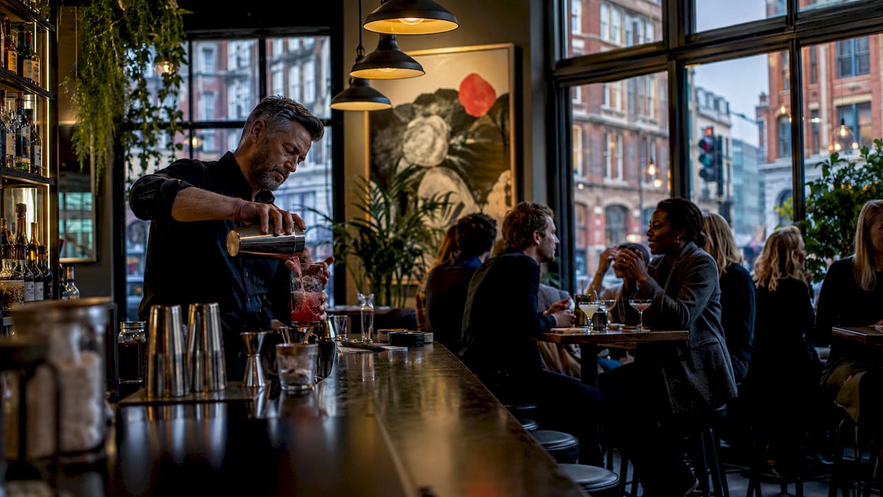 Interior view of a traditional London pub with bartender and patrons