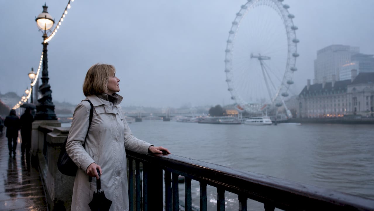 Visitor looking at London Eye on overcast day